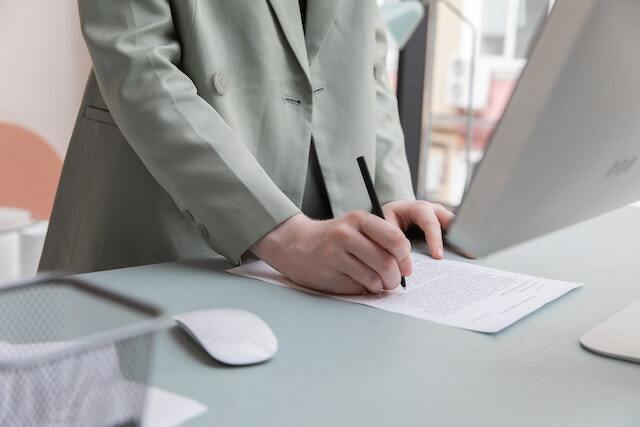 singing a contract at a desk in front of a computer